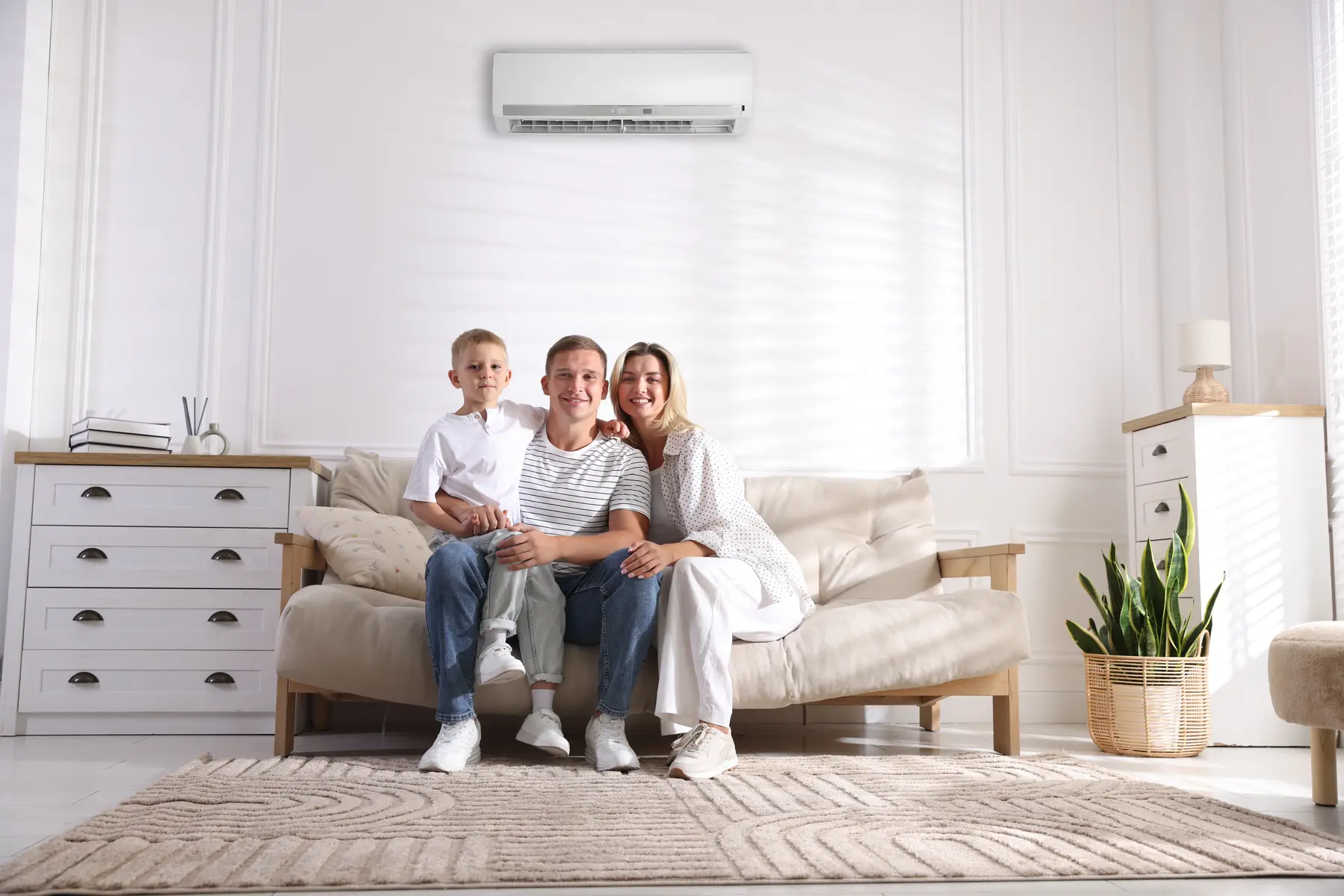 Famille heureuse profitant d'un salon frais et climatisé à Carqueiranne, installation réalisée par l'artisan expert Pro Clim Var.